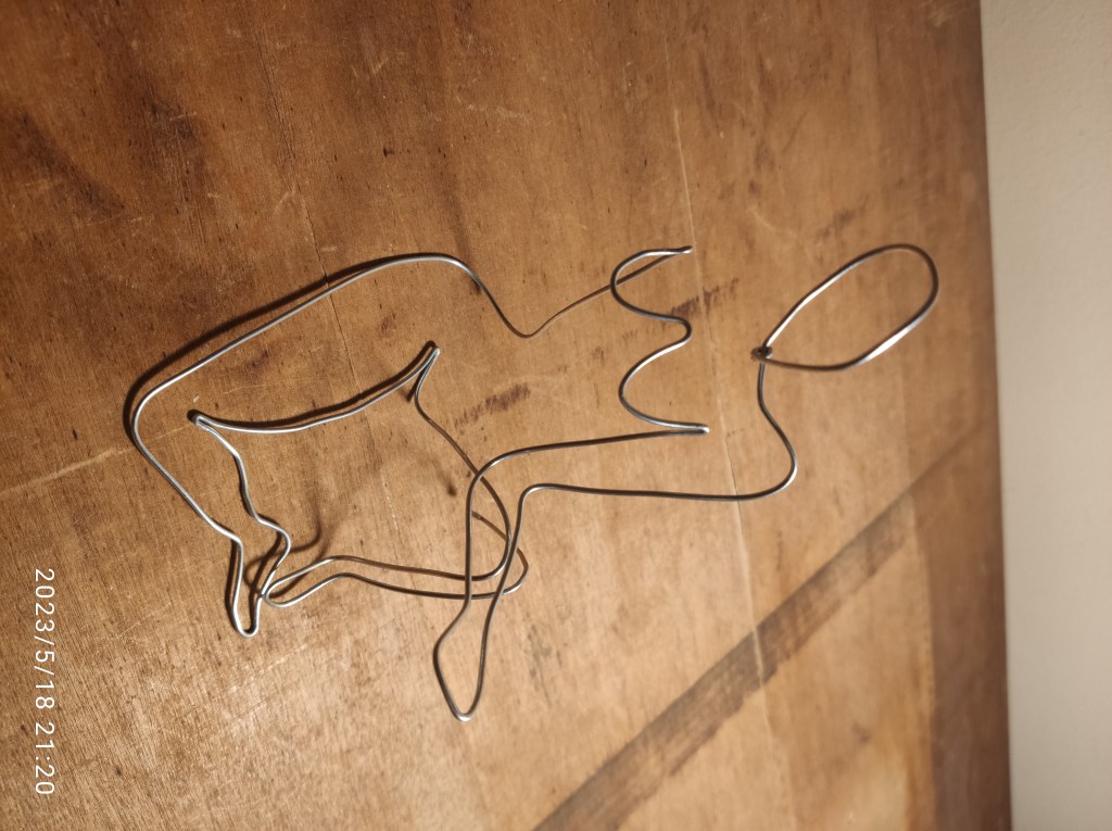 Seated woman, wire sculpture by Nilo Saba